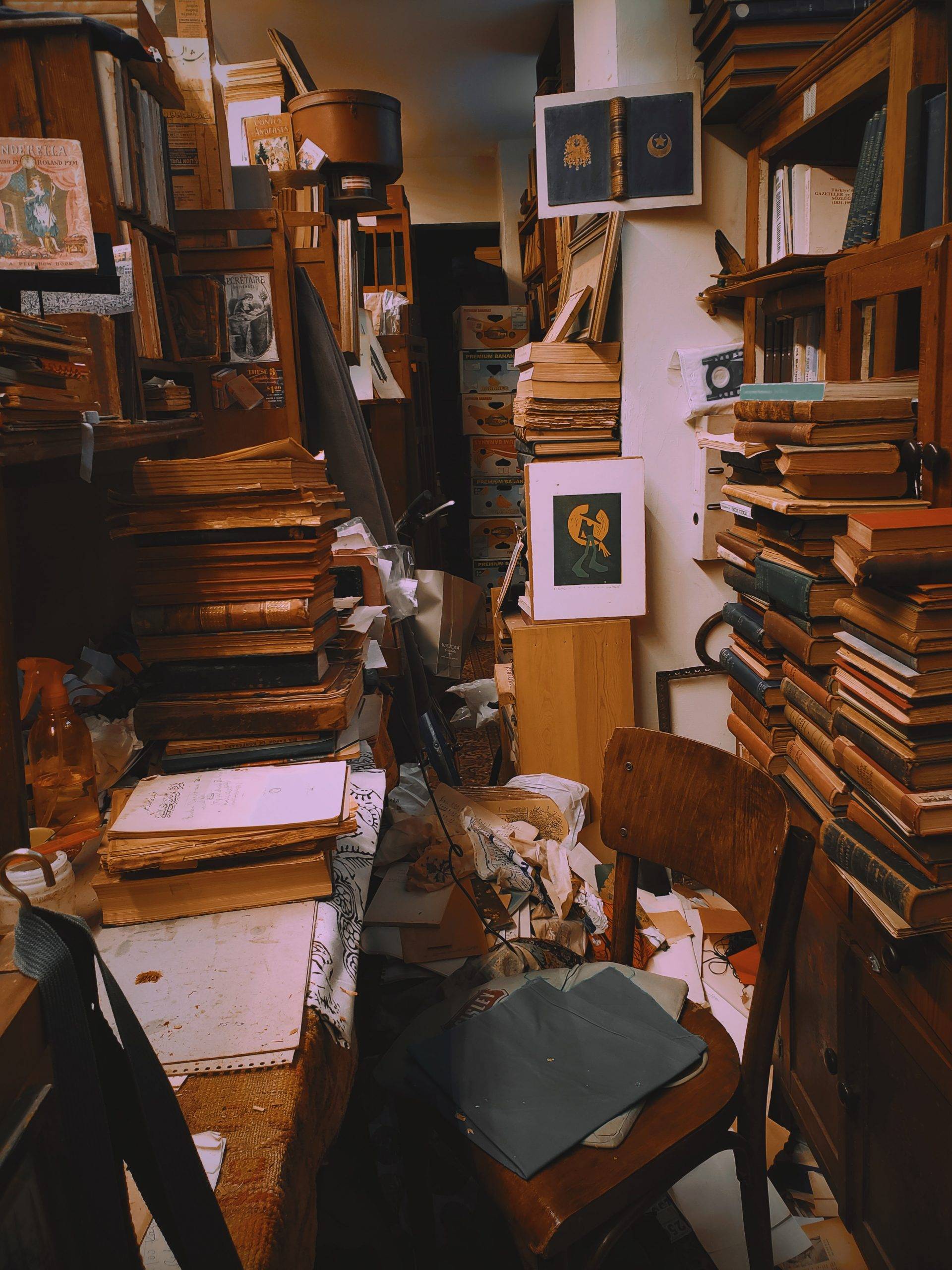 An office filled with lots of clutter like books and paper