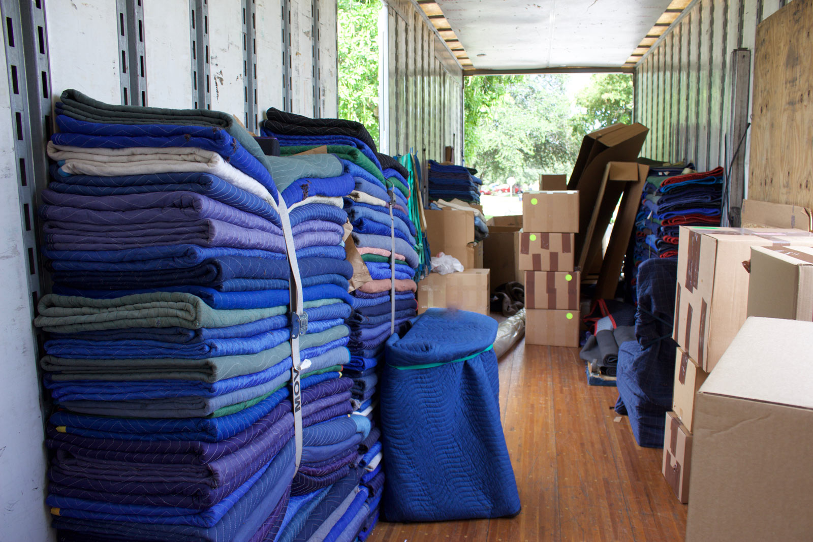 Moving and storage trailer with strapped moving blankets and packing supplies